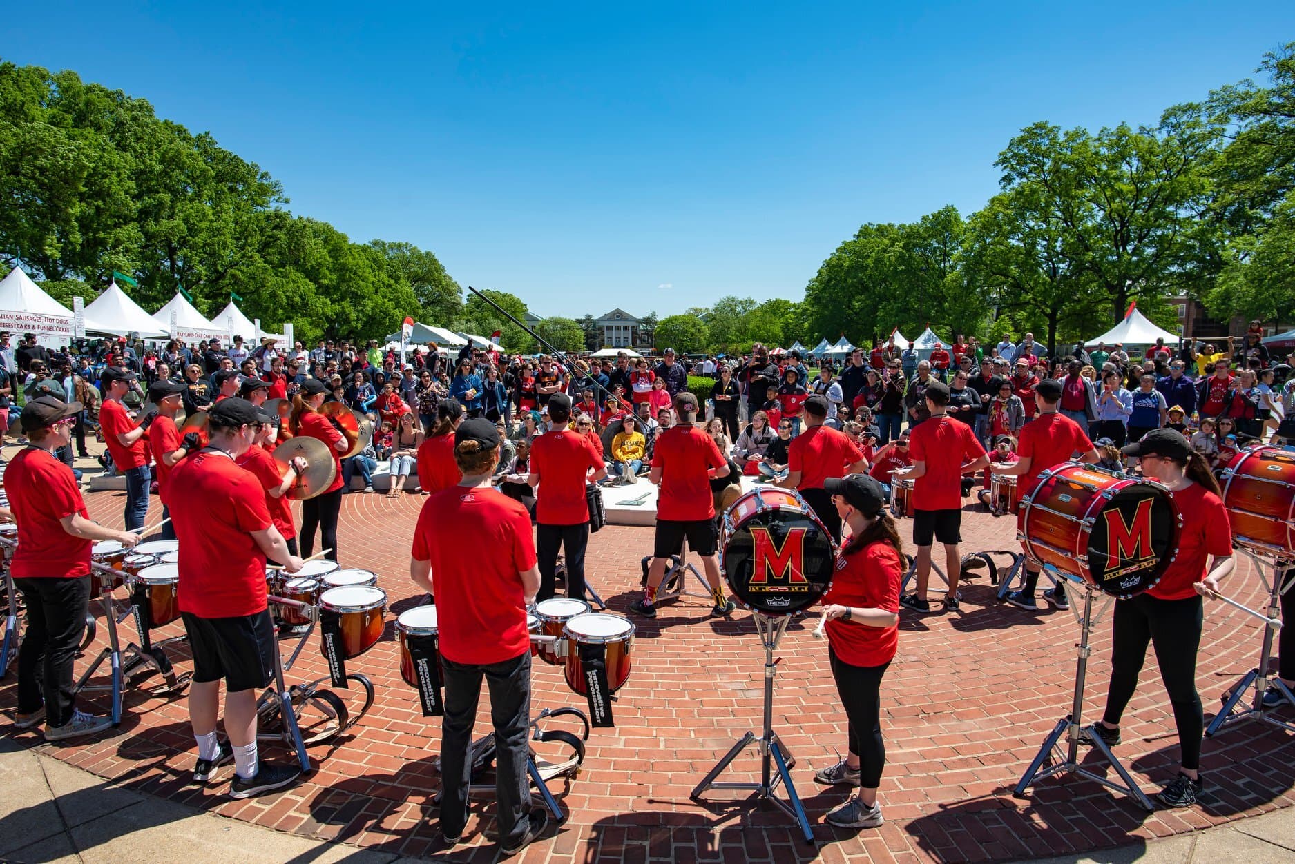 The Mighty Sound of Maryland drum line perform for Maryland Day attendees at the McKeldin Mall sundial, honoring Dutch astronomer Uco van Wijk